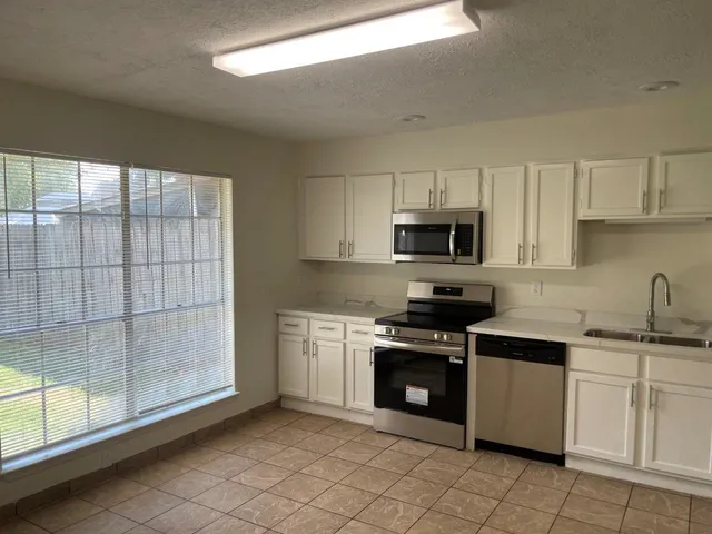a kitchen with cabinets and white stainless steel appliances