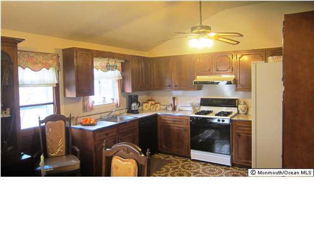 84 North Cooks Bridge Road Jackson, NJ 08527 - Photo 2 of 3 a kitchen with stainless steel appliances kitchen island granite countertop a sink dishwasher a stove a refrigerator and a dining table with wooden cabinet