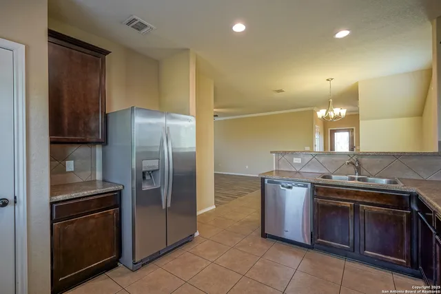a kitchen with stainless steel appliances granite countertop a stove a refrigerator and a sink