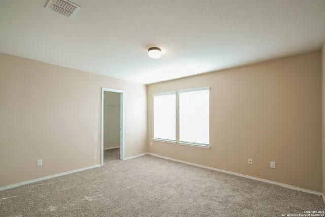an empty room with windows and closet