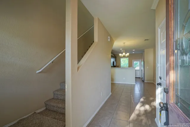 a view of a hallway with wooden floor and a bathroom