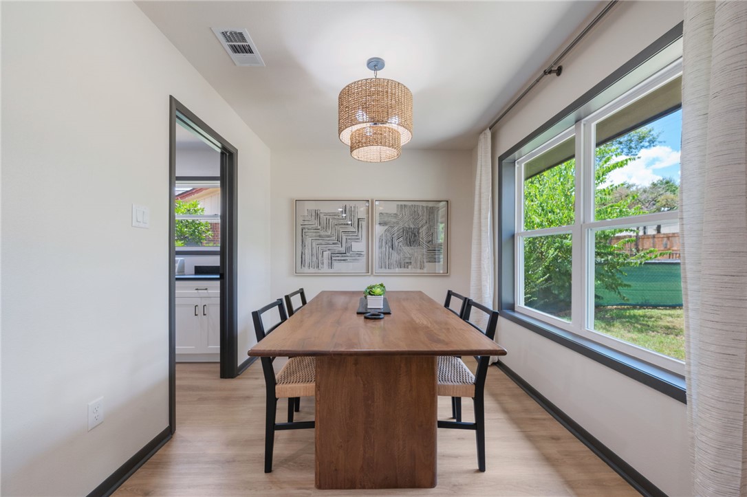 1509 Barak Lane Bryan, TX 77802 - Photo 15 of 24 a dining room with wooden floor a chandelier a wooden table and chairs