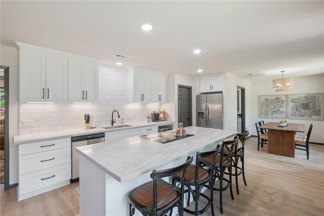 1509 Barak Lane Bryan, TX 77802 - Photo 9 of 24 a kitchen with a dining table chairs and white stainless steel appliances