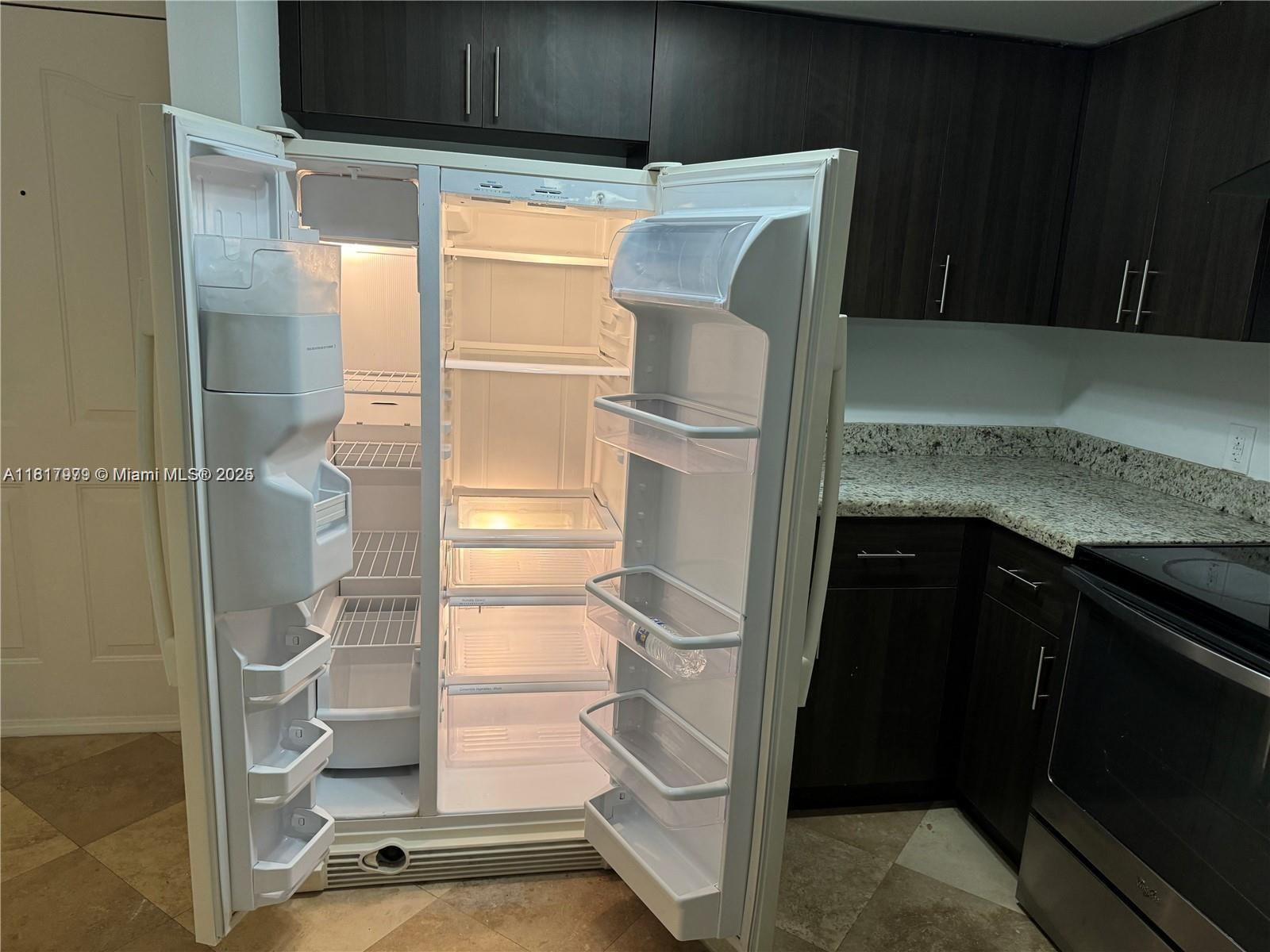 5091 Northwest 7th Street, Unit 615 Miami, FL 33126 - Photo 11 of 40 a kitchen with a refrigerator and cabinets