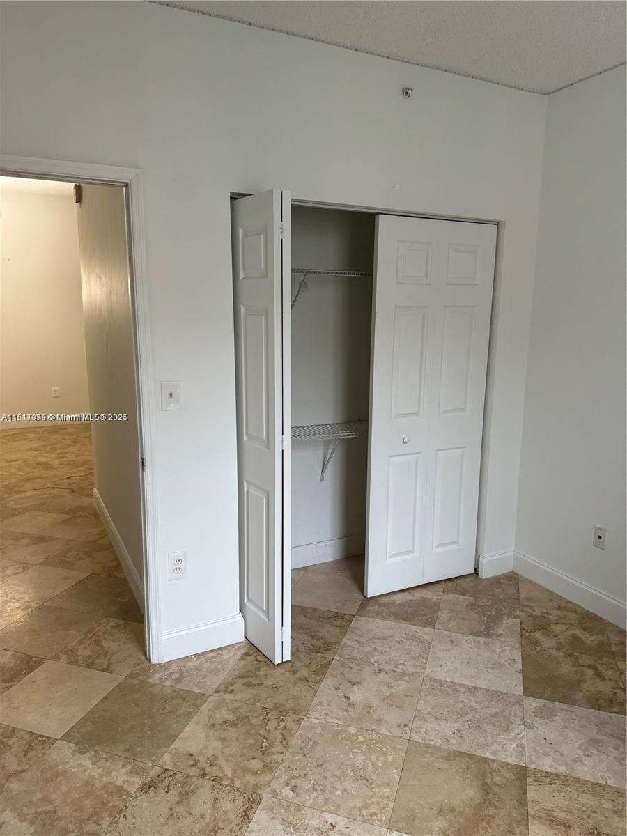 5091 Northwest 7th Street, Unit 615 Miami, FL 33126 - Photo 19 of 40 an empty room with closet area