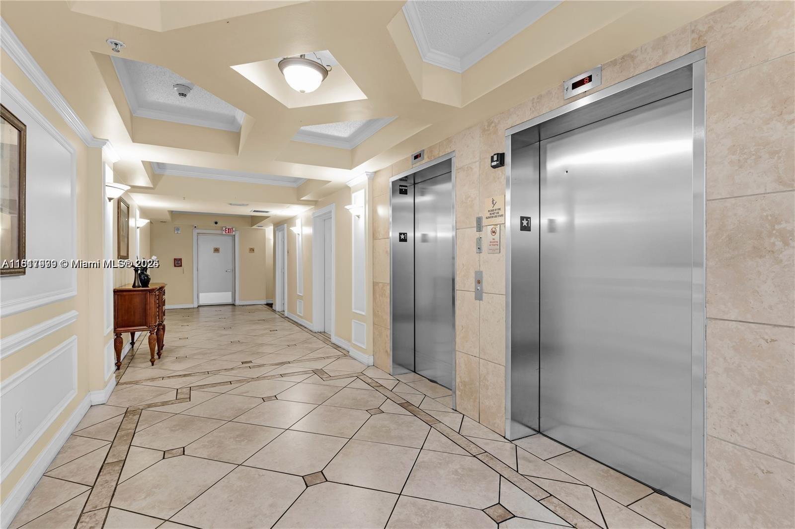 5091 Northwest 7th Street, Unit 615 Miami, FL 33126 - Photo 3 of 40 a view of a hallway with dining area and chandelier