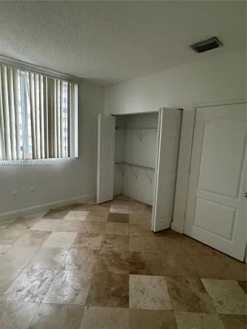 an empty room with windows and closet
