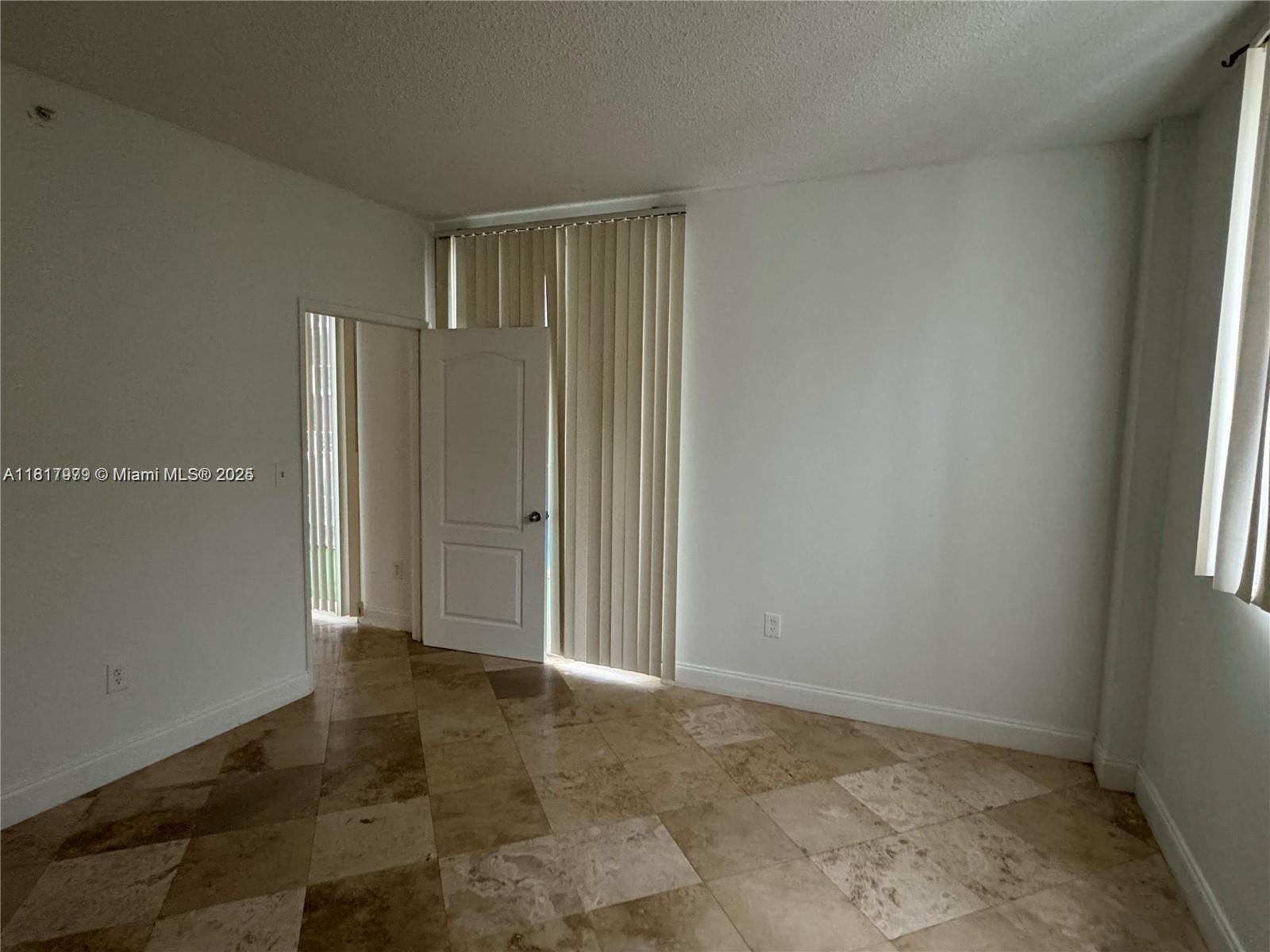 5091 Northwest 7th Street, Unit 615 Miami, FL 33126 - Photo 33 of 40 an empty room with windows and closet