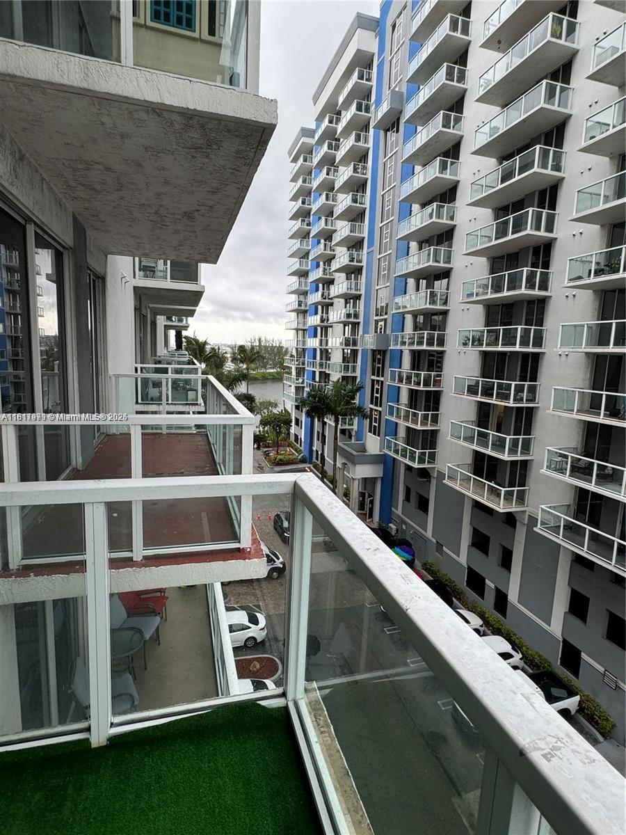 5091 Northwest 7th Street, Unit 615 Miami, FL 33126 - Photo 36 of 40 a view of balcony with a large window and wooden fence