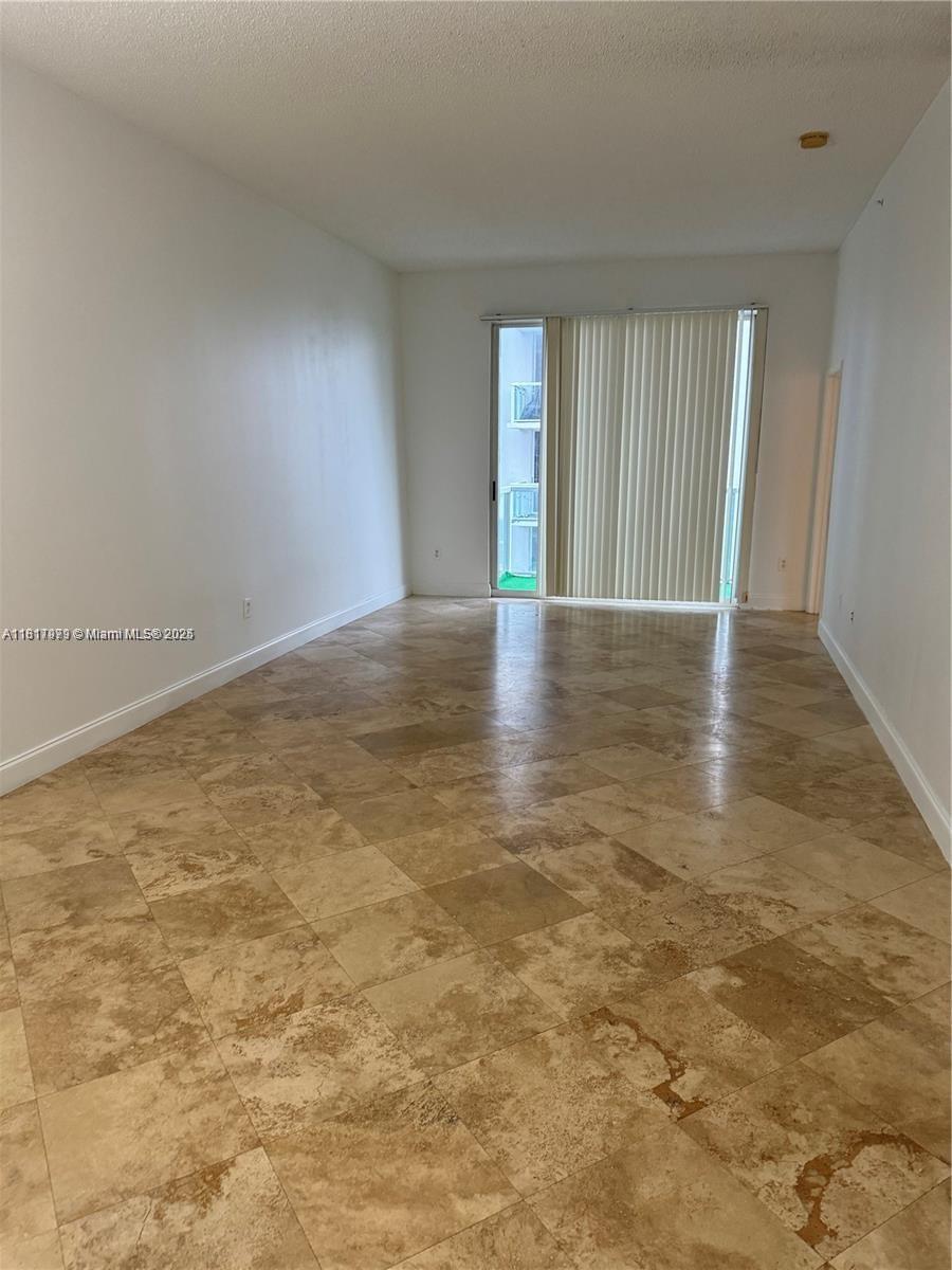 5091 Northwest 7th Street, Unit 615 Miami, FL 33126 - Photo 5 of 40 an empty room with wooden floor and windows