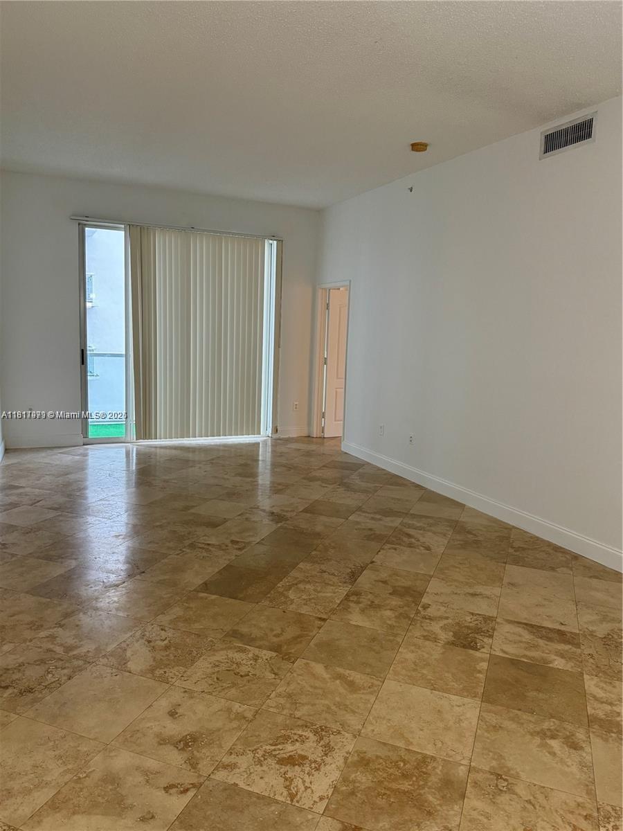 5091 Northwest 7th Street, Unit 615 Miami, FL 33126 - Photo 6 of 40 a view of an empty room with wooden floor and a window