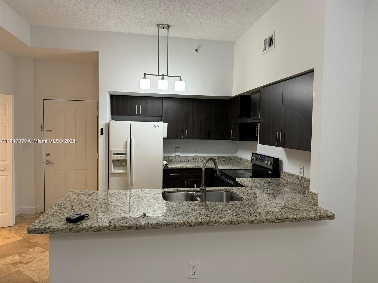5091 Northwest 7th Street, Unit 615 Miami, FL 33126 - Photo 8 of 40 a view of a kitchen with a sink stainless steel appliances and cabinets
