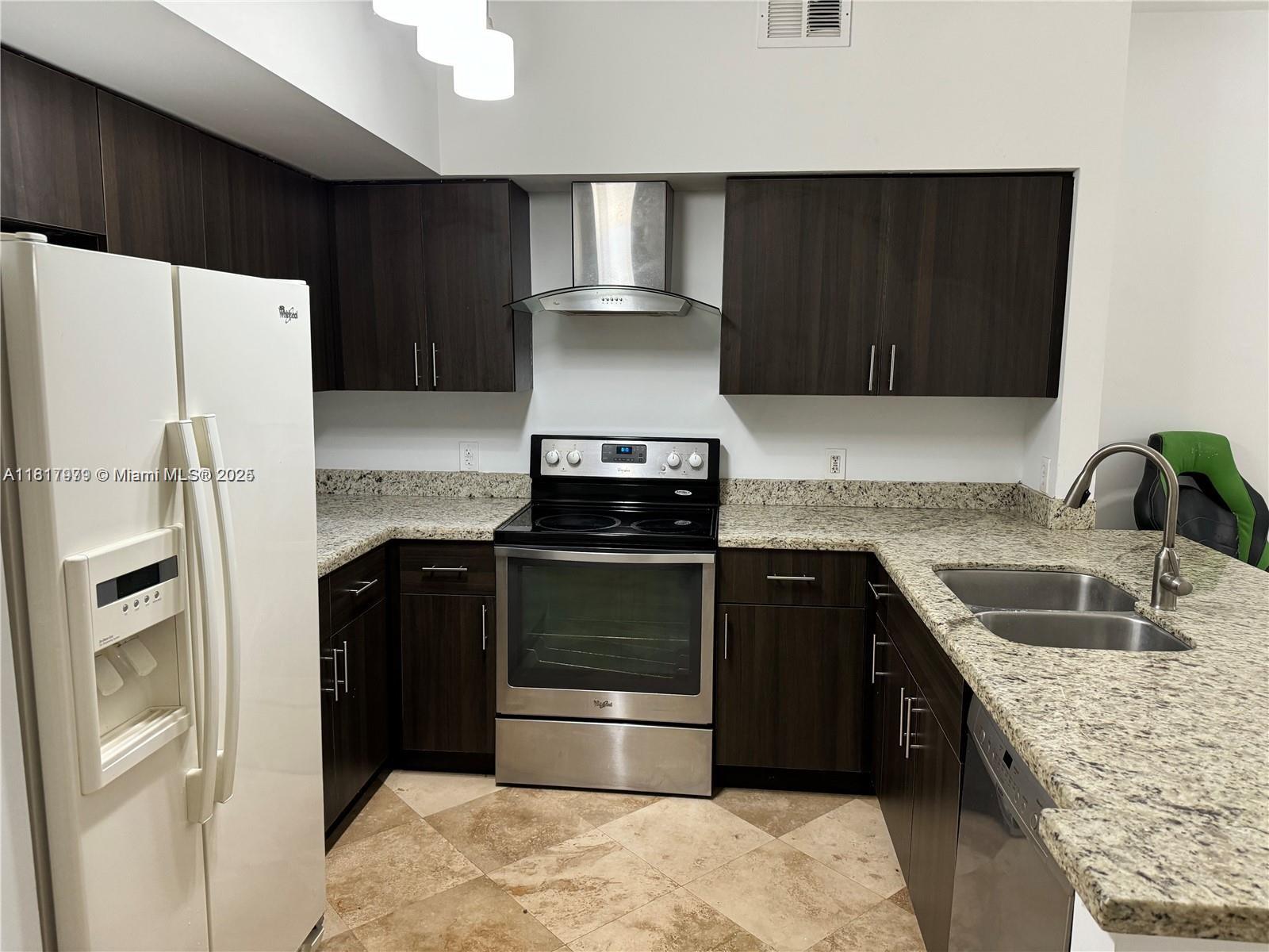 5091 Northwest 7th Street, Unit 615 Miami, FL 33126 - Photo 10 of 40 a kitchen with granite countertop a refrigerator stove and sink