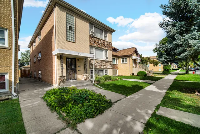 a front view of a house with a yard and trees