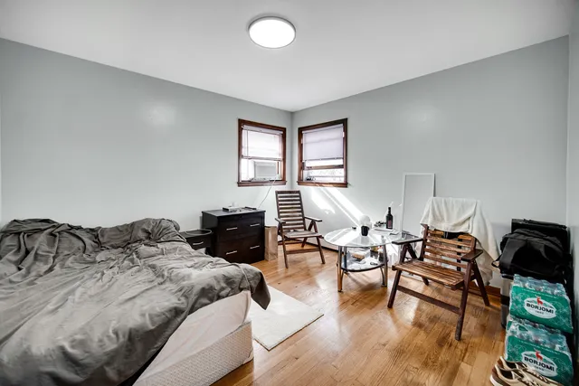 a bedroom with a bed and wooden floor