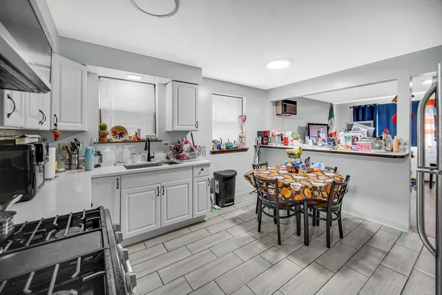 a kitchen with a dining table chairs sink and cabinets