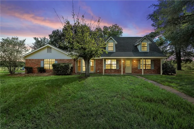 a front view of a house with a yard and trees