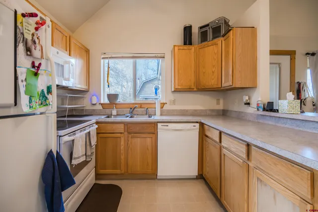 a kitchen with stainless steel appliances granite countertop a sink and a stove next to a window