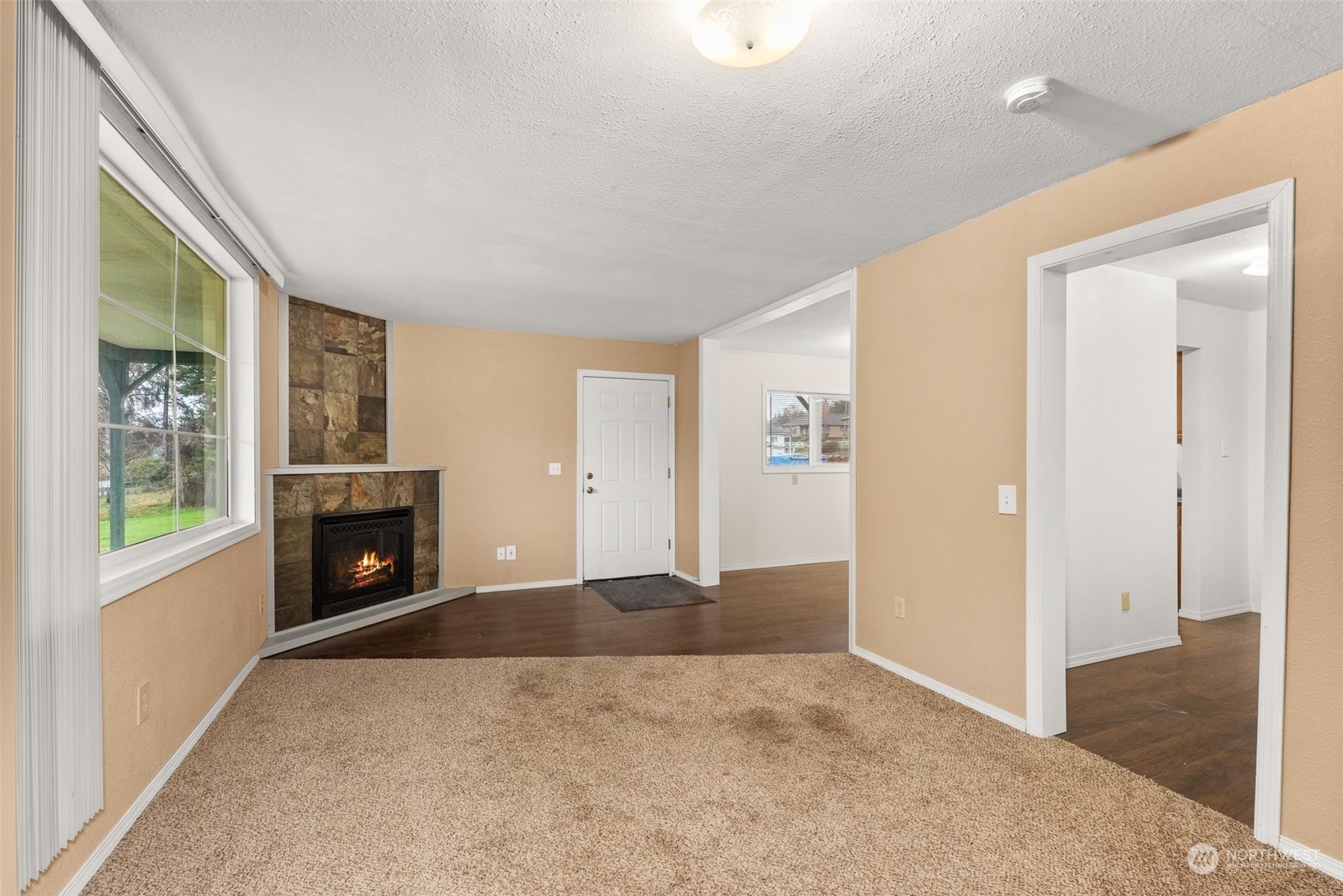2131 Stuart Street Raymond, WA 98577 - Photo 7 of 25 an empty room with windows fireplace and wooden floor