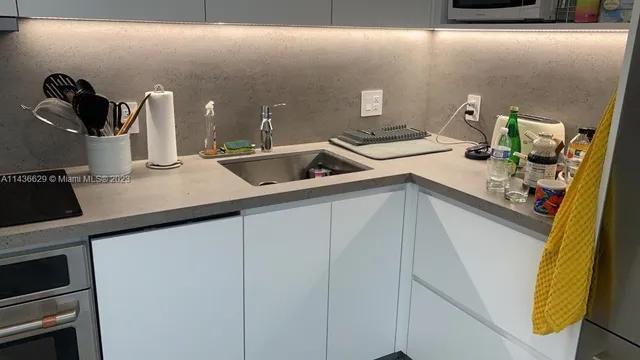 a kitchen with a sink and a stove top oven