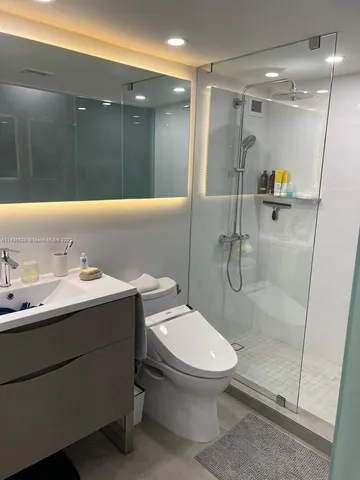 a bathroom with a sink a toilet and shower