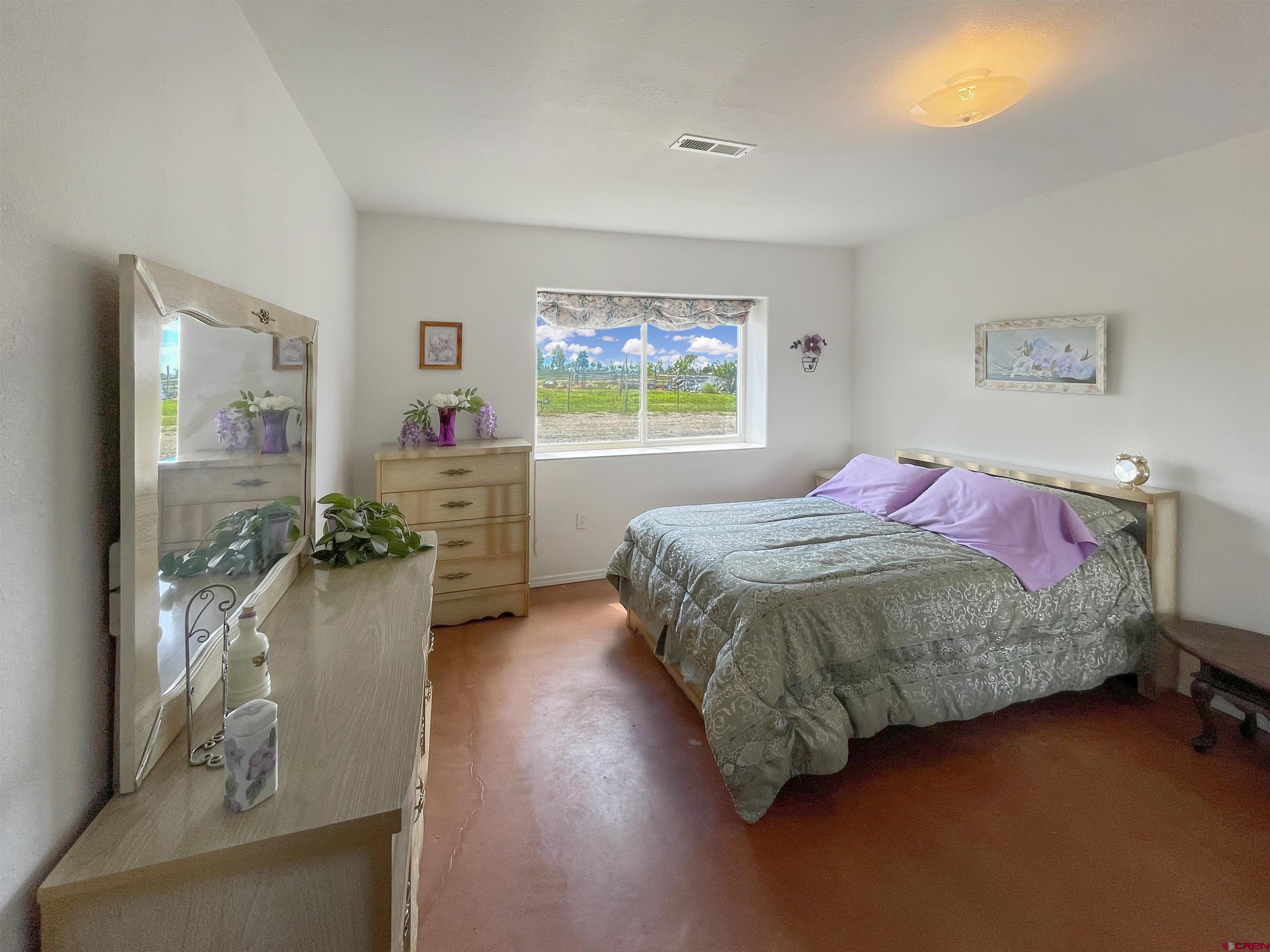 25970 Rd P Cortez, CO 81321 - Photo 16 of 20 a spacious bedroom with a bed mirror and window