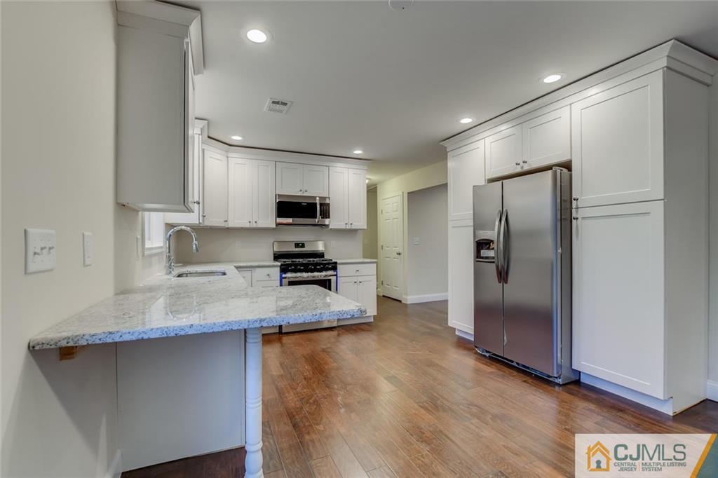 41 Emerson Road Somerset, NJ 08873 - Photo 11 of 25 a kitchen with stainless steel appliances granite countertop a refrigerator a stove a sink and a microwave