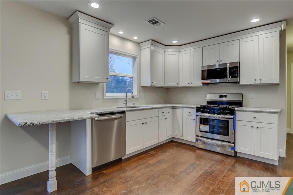 41 Emerson Road Somerset, NJ 08873 - Photo 12 of 25 a kitchen with stainless steel appliances granite countertop a stove sink and cabinets