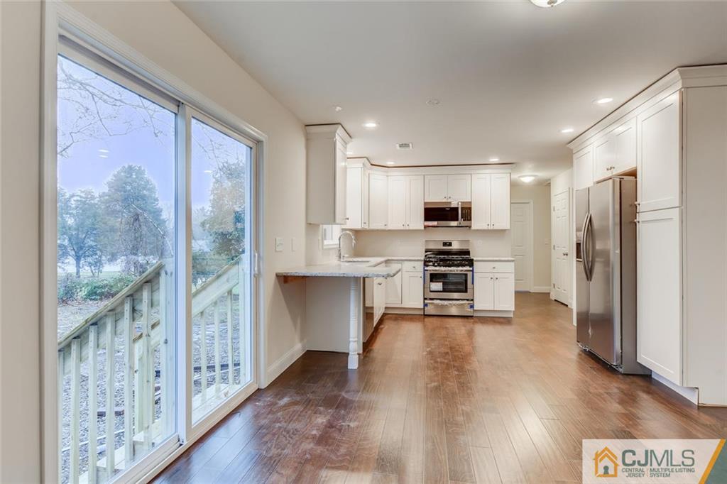 41 Emerson Road Somerset, NJ 08873 - Photo 13 of 25 a kitchen with granite countertop a refrigerator and a stove top oven