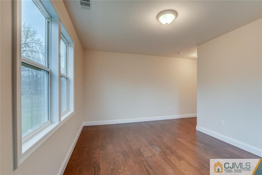 41 Emerson Road Somerset, NJ 08873 - Photo 17 of 25 an empty room with wooden floor and windows