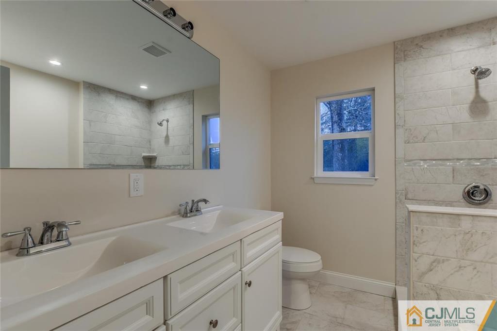 41 Emerson Road Somerset, NJ 08873 - Photo 21 of 25 a bathroom with a granite countertop sink a toilet and a mirror
