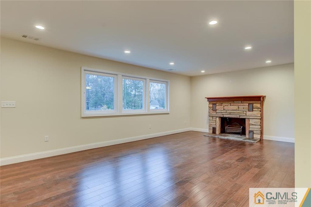41 Emerson Road Somerset, NJ 08873 - Photo 4 of 25 an empty room with wooden floor fireplace and windows