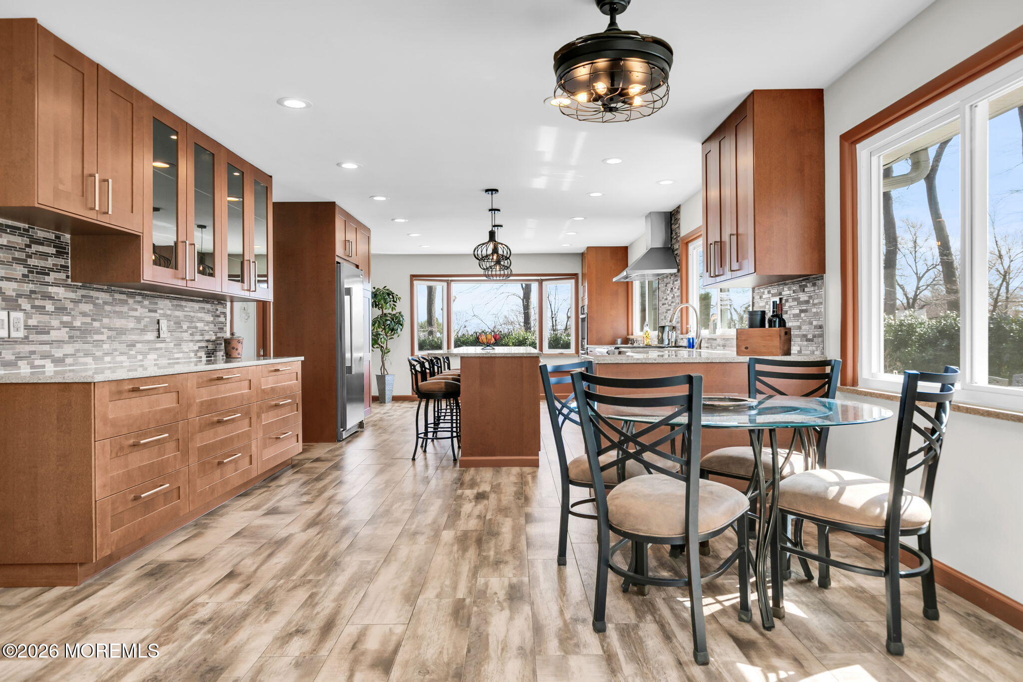 12 Crest Drive Colts Neck, NJ 07722 - Photo 19 of 77 a dining room with stainless steel appliances kitchen island granite countertop a table chairs and a wooden cabinets