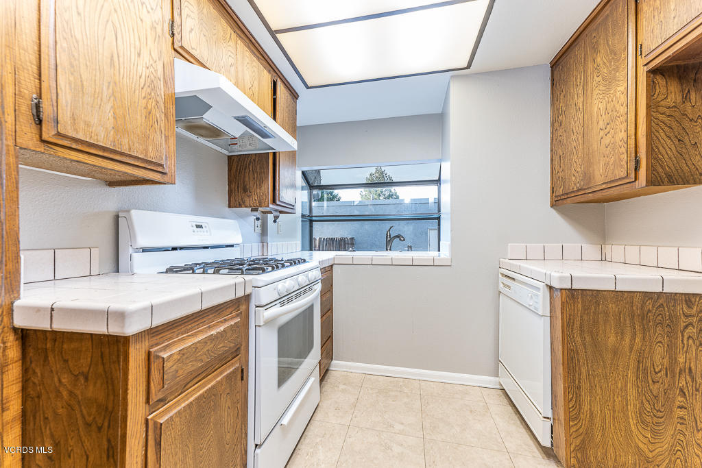 6400 Katherine Road, Unit C Simi Valley, CA 93063 - Photo 9 of 26 a kitchen with stainless steel appliances granite countertop a refrigerator a stove and a sink with wooden cabinets