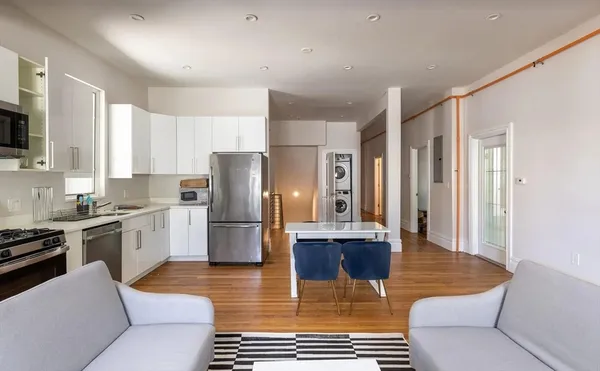 a kitchen with stainless steel appliances granite countertop a refrigerator a stove a sink and a refrigerator