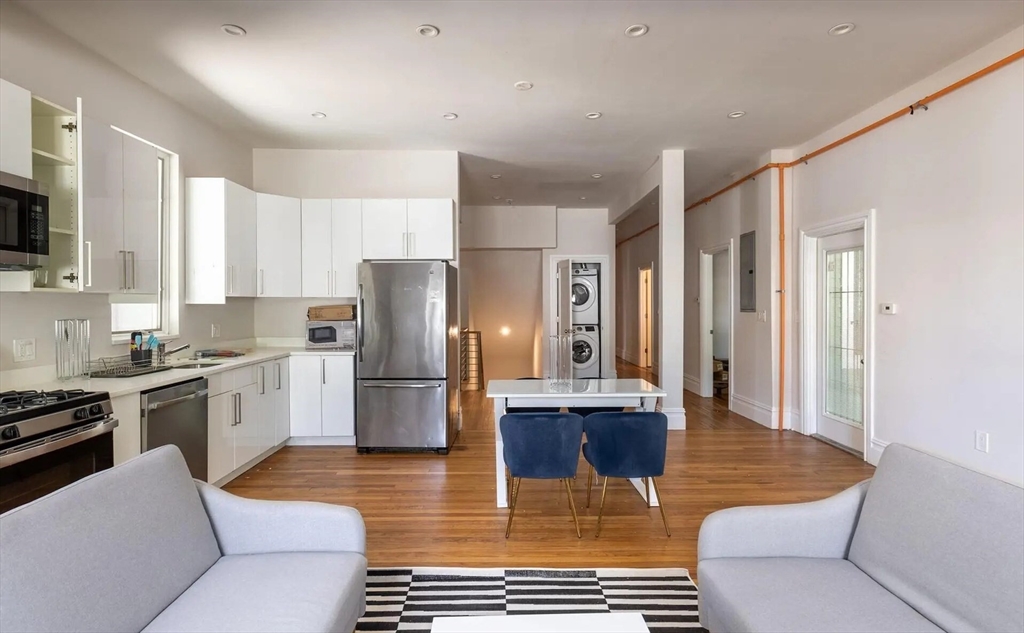 a kitchen with stainless steel appliances granite countertop a refrigerator a stove a sink and a refrigerator