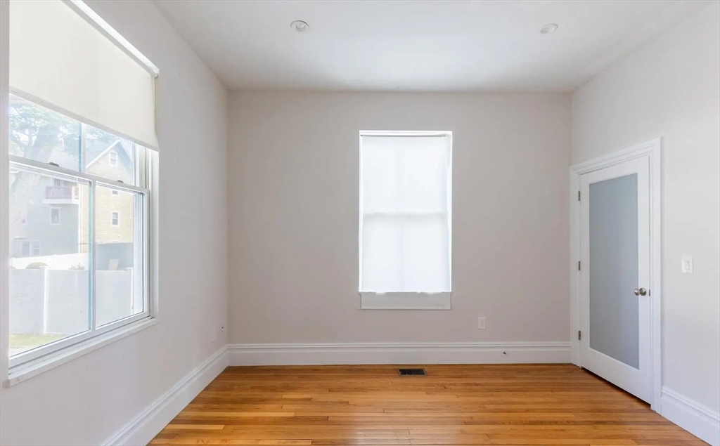 89 Cedar Street, Unit 2 Boston, MA 02119 - Photo 15 of 27 a view of an empty room with wooden floor and a window