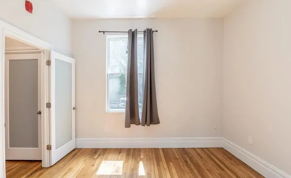 an entryway with wooden floor and a window