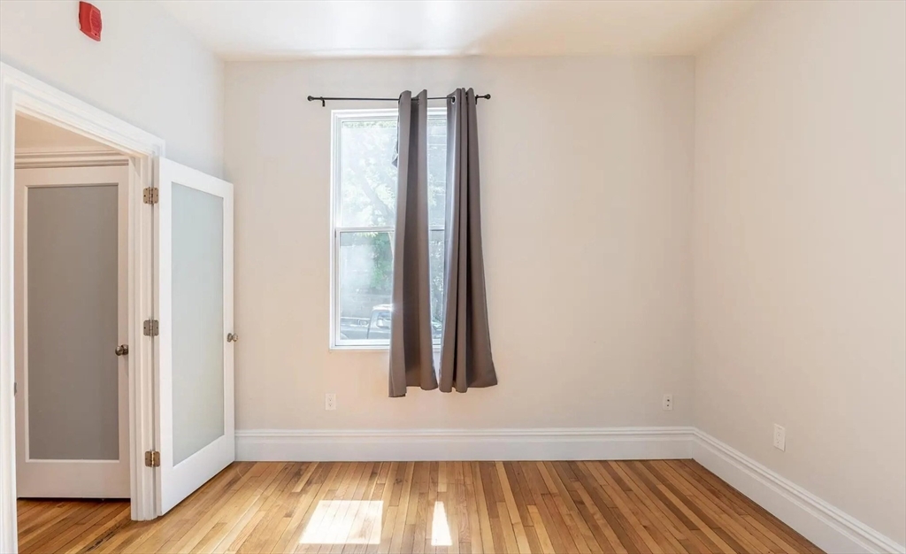 89 Cedar Street, Unit 2 Boston, MA 02119 - Photo 22 of 27 an entryway with wooden floor and a window