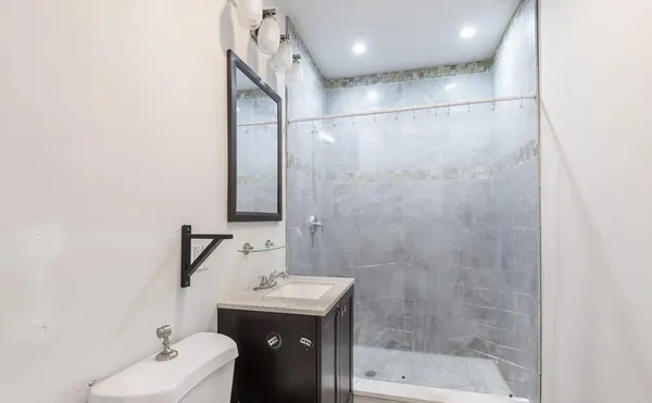 a bathroom with a sink mirror and shower