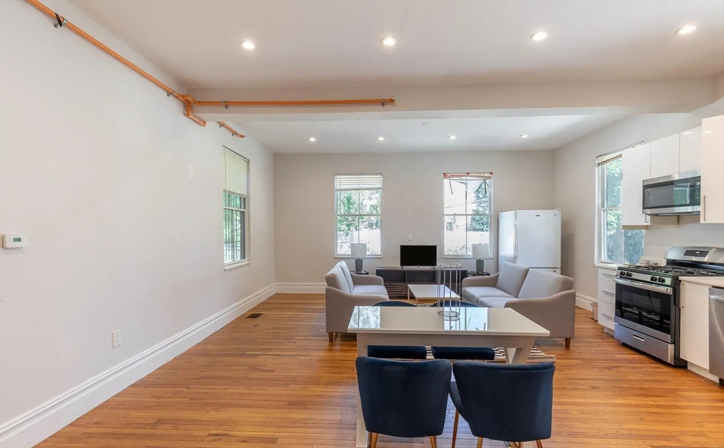 89 Cedar Street, Unit 2 Boston, MA 02119 - Photo 4 of 27 a view of a kitchen with kitchen island granite countertop a sink counter top space and stainless steel appliances