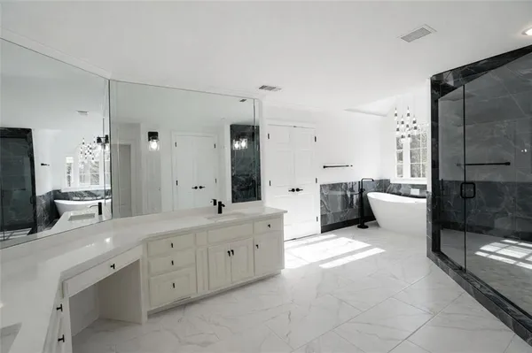 a large bathroom with a double vanity sink a large mirror and shower