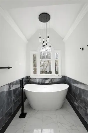 a white bath tub sitting next to a blue white and blue cabinets