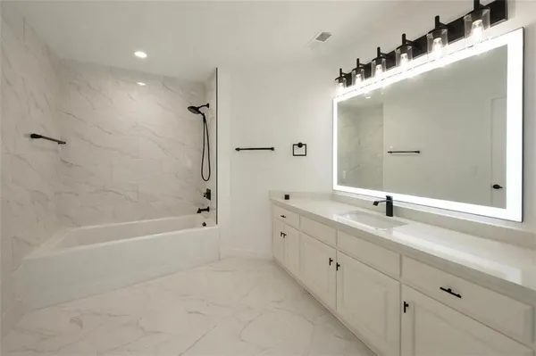 a bathroom with a tub sink and mirror