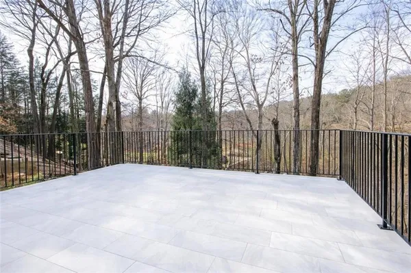 a view of backyard with wooden fence and large trees