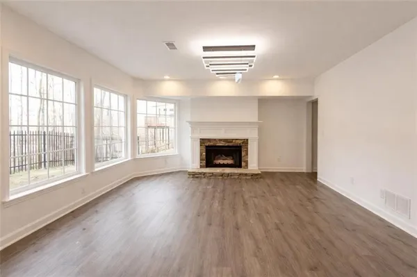 wooden floor fireplace and windows in an empty room
