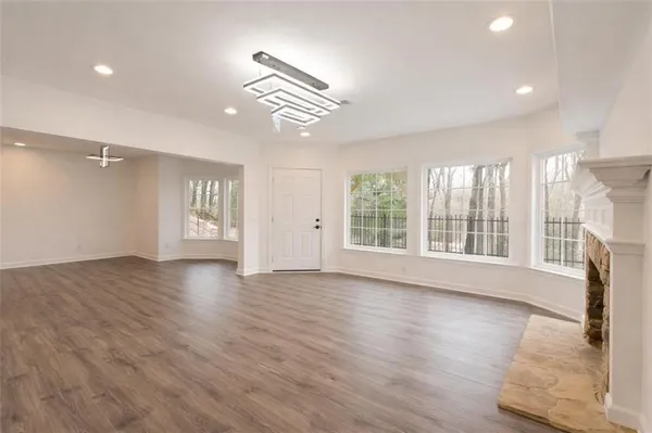 a view of an empty room with a window and wooden floor
