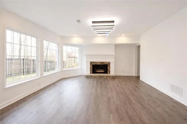 a view of empty room with wooden floor and fireplace