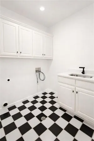 a kitchen with a checkered floor and white cabinets