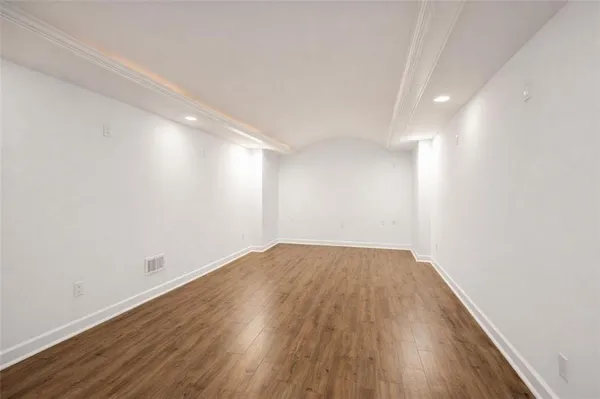 a view of an empty room with wooden floor